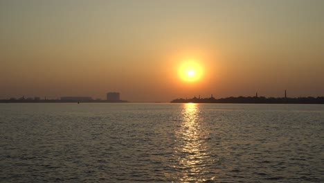 the sun is setting on the other side of the river where civilization has developed