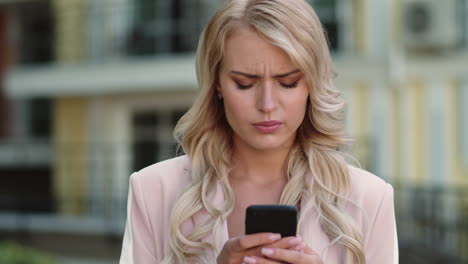 Portrait-of-serious-businesswoman-using-smartphone-outdoor