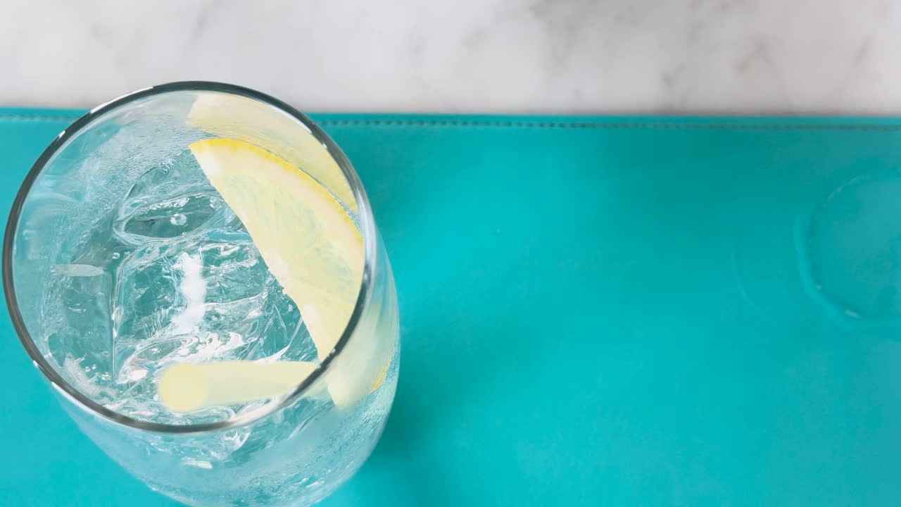 un refrescante vaso de refresco de club con una rebanada de limón, visto desde arriba, mostrando burbujas y colores vibrantes