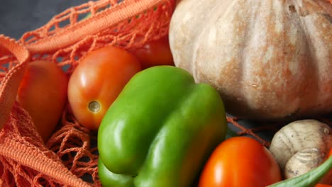 assortment of fresh vegetables in an orange mesh bag