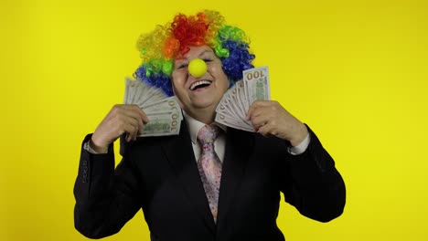 Elderly-clown-businesswoman-freelancer-boss-dancing-with-money-cash-banknotes