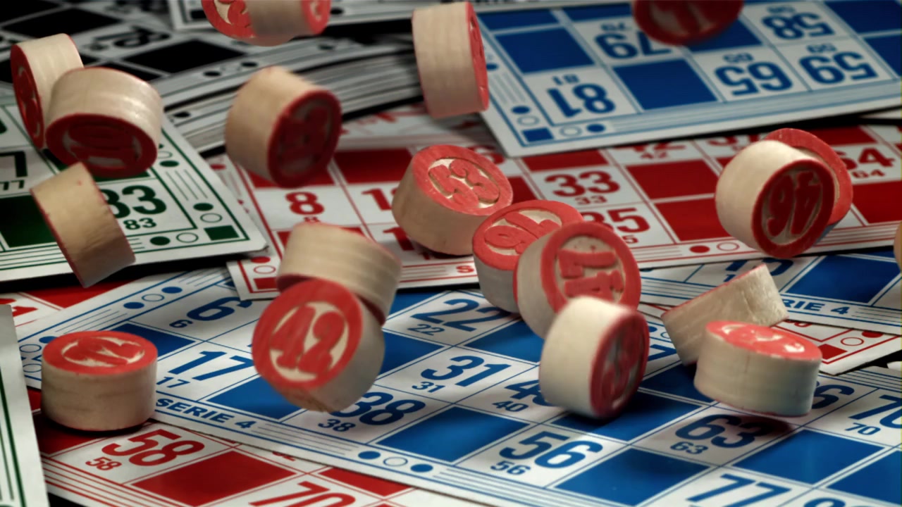Movimento rallentato di fiches da bingo che cadono su cartelle da gioco