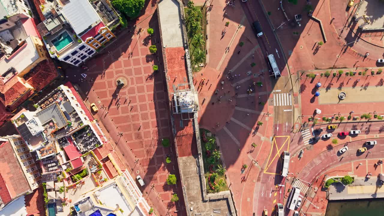 Slow motion top down aerial view of cartagena's clock tower plaza, showcasing the bustling city life and historical architecture