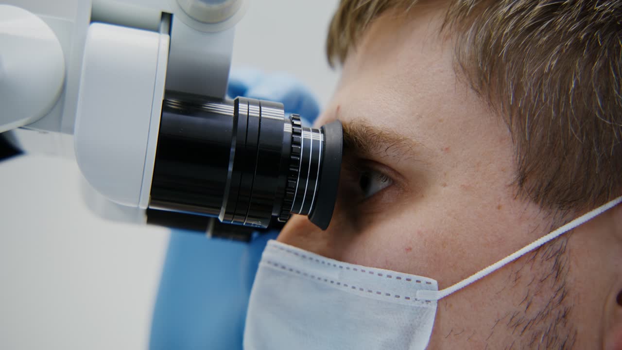 dentista examinando al paciente con el microscopio