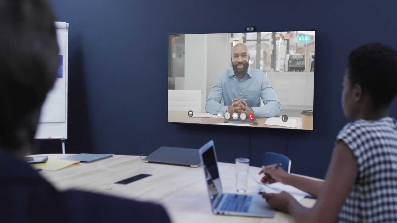 Diverse business people on video call with african american male colleague on screen