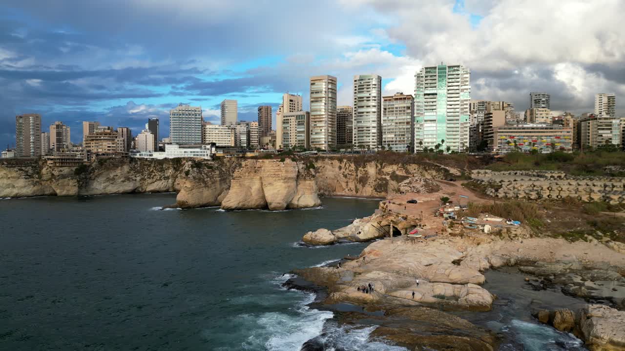 drone disparado volando hacia atrás sobre las rocas en la costa de la ciudad de beirut líbano