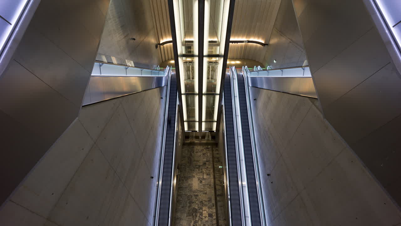 The underground station for Bybanen at Haukeland hospital in Bergen, Norway. Symmetrical escalators and a lift, with people moving up and down.
