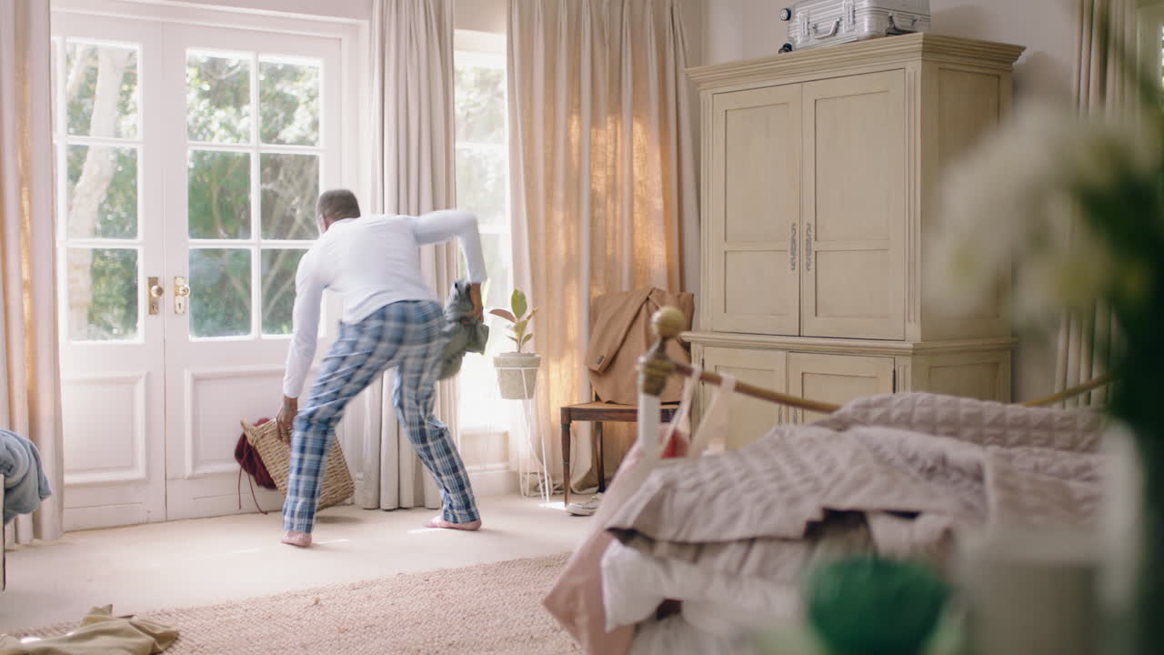 funny african american man dancing in bedroom having fun celebrating feeling positive enjoying successful lifestyle doing silly dance at home on weekend morning wearing pajamas