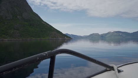 embarcaciones de vela a través de un río prístino con un paisaje montañoso de fondo en noruega