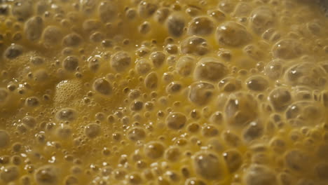 green boiling sauce texture close-up macro. cooking green curry with wooden spoon at home.