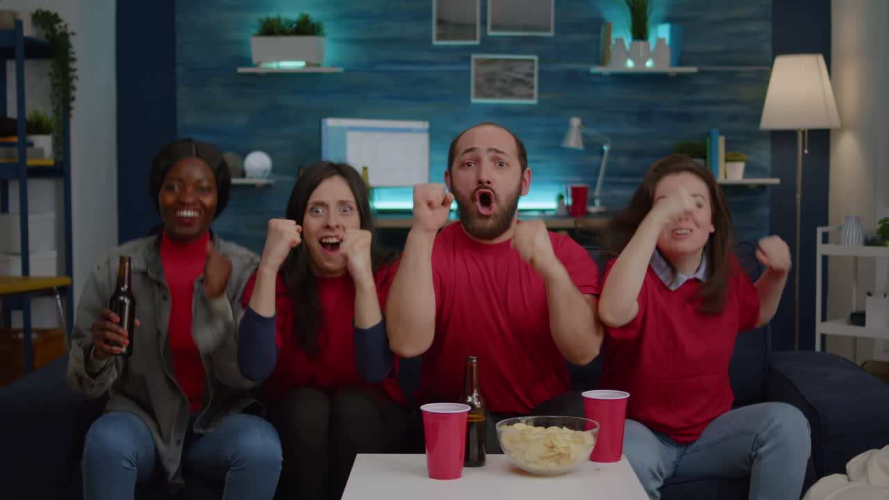 soportar a los fanáticos multiétnicos viendo deportes en la televisión juntos, bebiendo cerveza