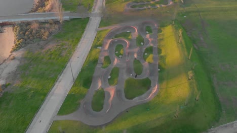 Aerial-top-down-forward-over-huge-park-near-Vasco-da-Gama-Bridge-at-sunrise,-Lisbon