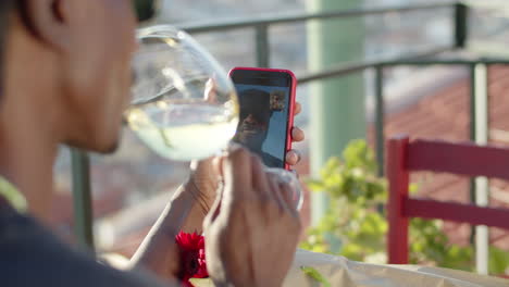 back view of man drinking wine and having video call with lover