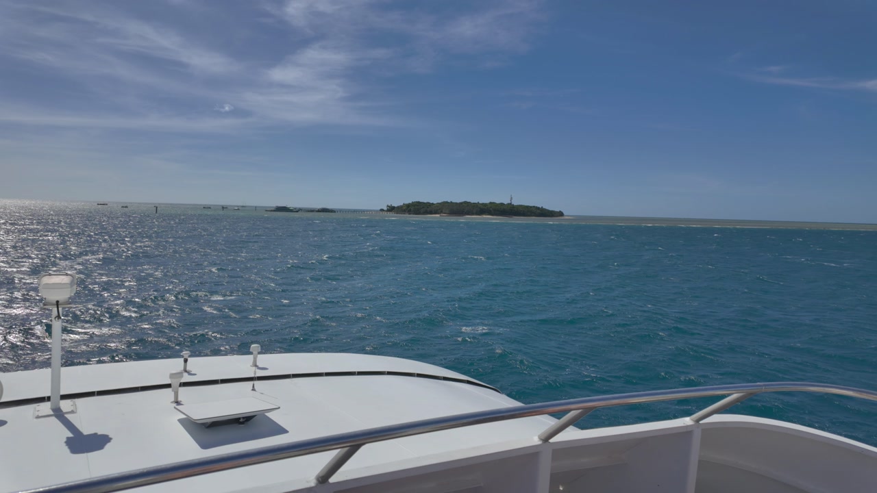 4K video of a boat approaching a tropical island in North Queensland in Australia