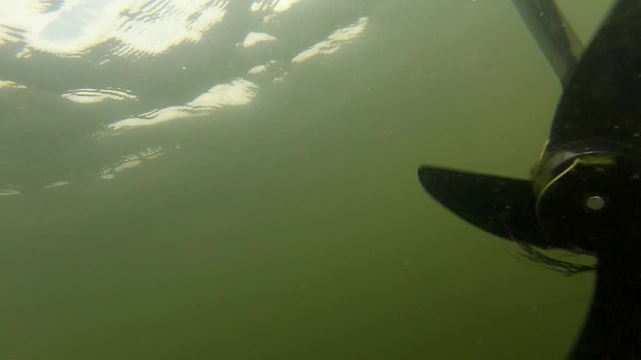Underwater View Of Spinning Motor Of A Moving Boat. - Underwater Shot
