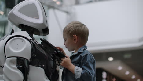 humanoid robot talks with child at technology exhibition. the exhibition park of robots. humanoid robot talks with