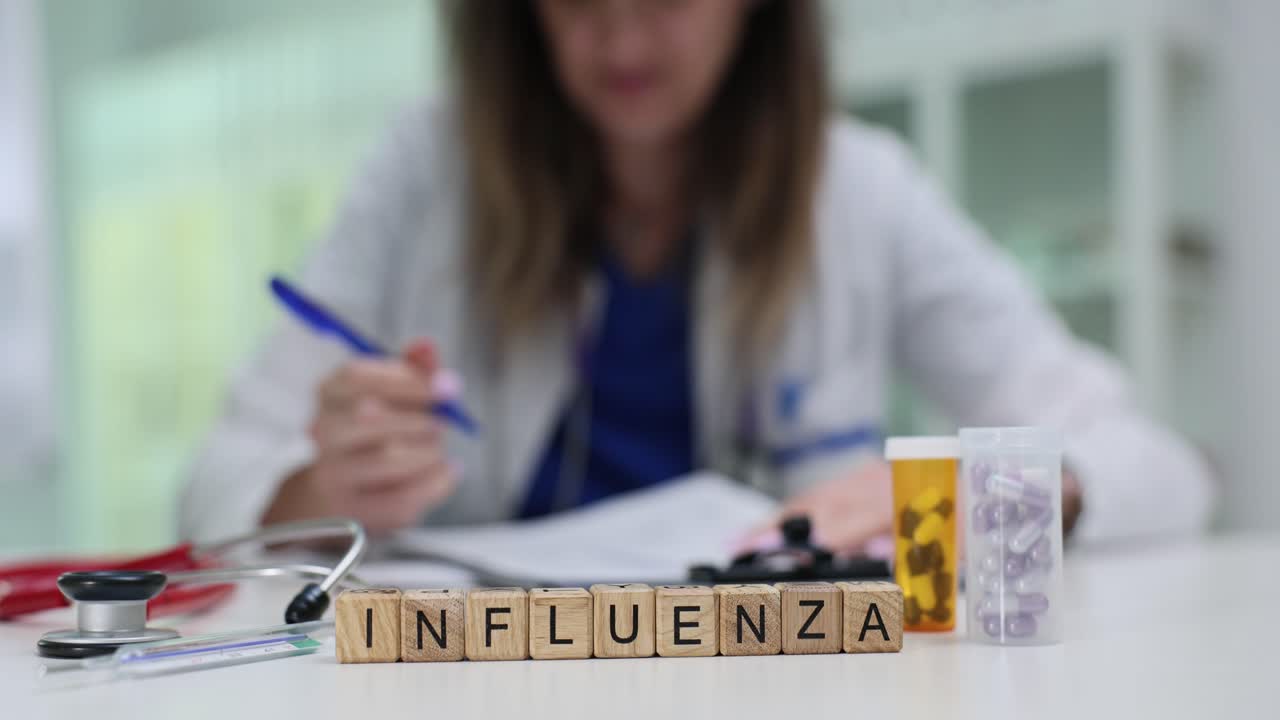 Influenza word blocks on a doctor's desk with medical supplies