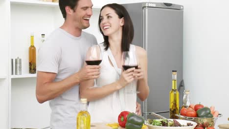 Pareja-Bebiendo-Vino-Y-Comiendo-Ensalada-En-La-Cocina