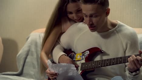 couple singing and playing guitar