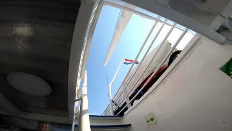 inside view of a ferry deck with lifeboat and dutch flag