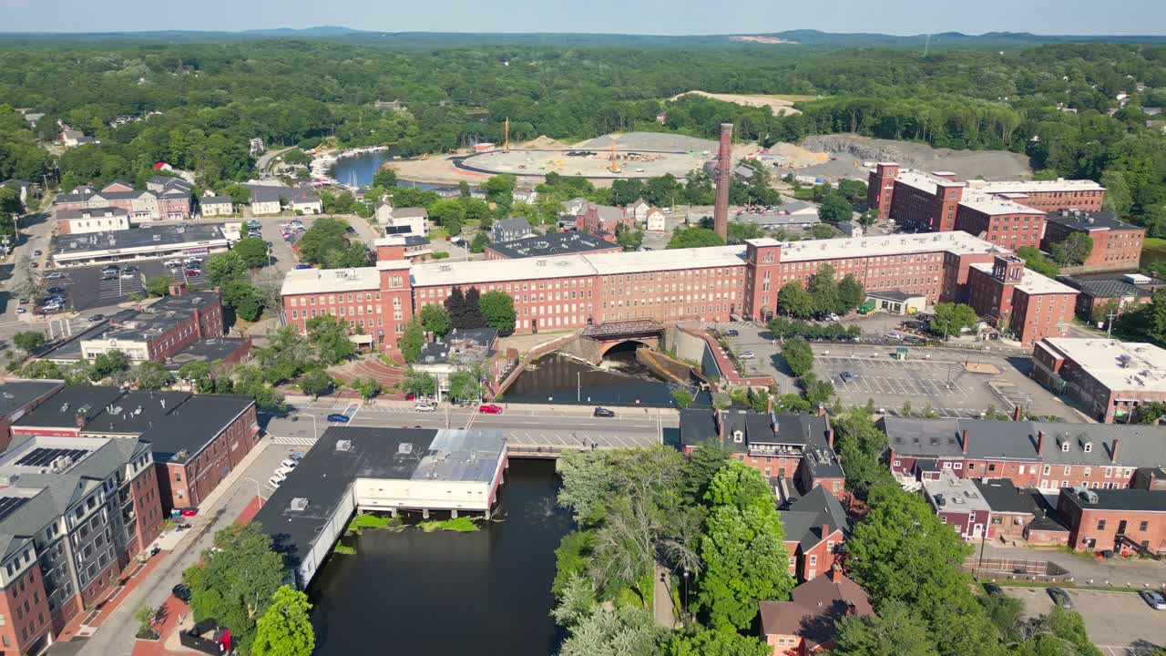 Sakte droneopptak som flyr over elven mot møllen i historiske sentrum av Dover, NH, USA. Det viser vakre mursteinsbygninger og omgivelser ved hovedgaten.