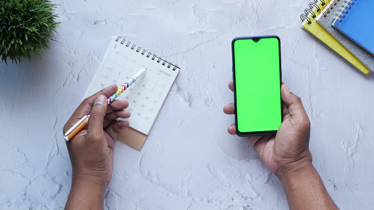 Person planning their schedule with a phone and calendar