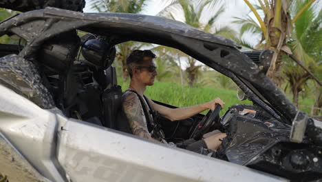 male sitting in dirt buggy with sunglasses turning to camera in punta cana