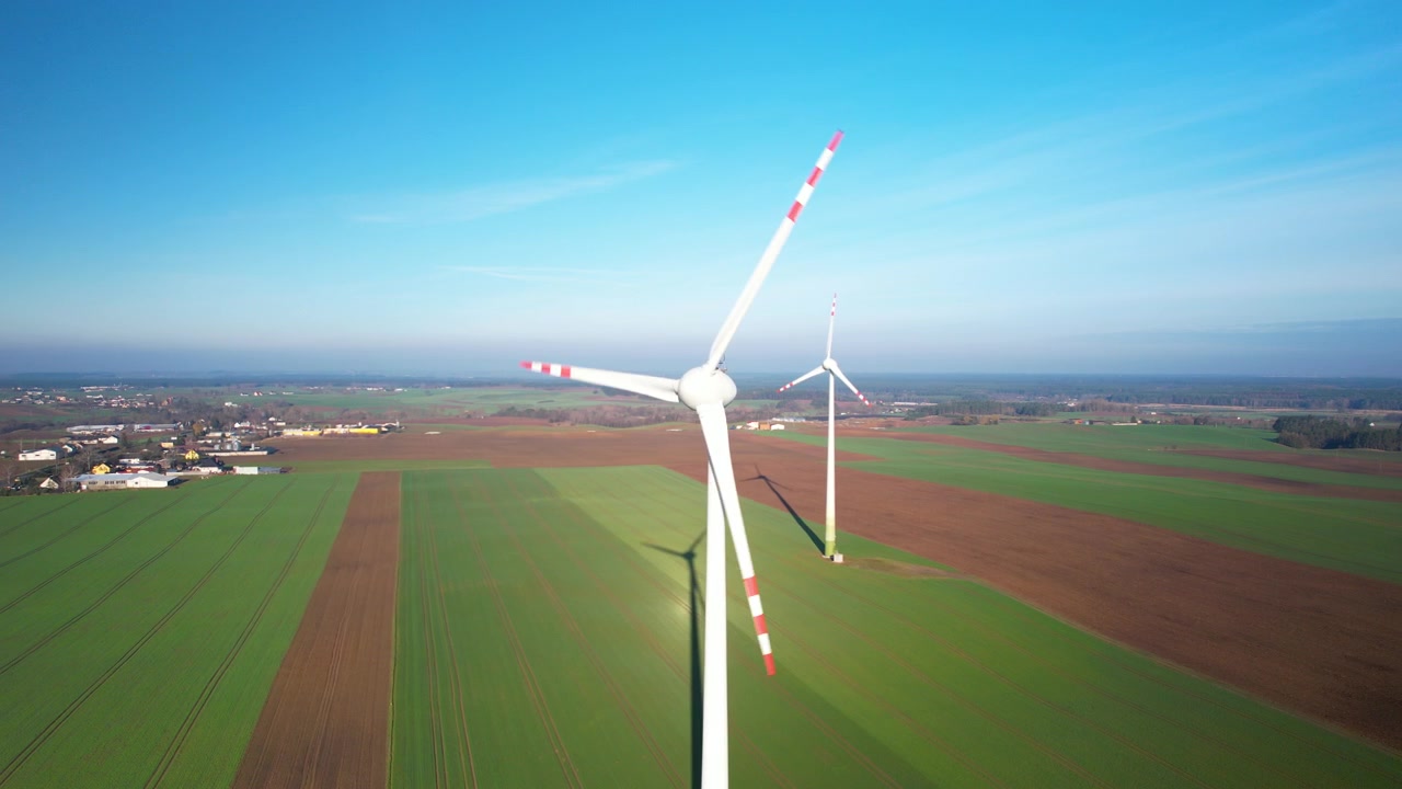 Aerial view of clean and renewable wind power farm in motion converting kinetic energy, modern electric industry environmental protection innovation ecosystem electricity generator wind turbines