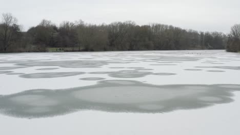 drone aerial footage of a 4k drone flying very close over a frozen lake in germany