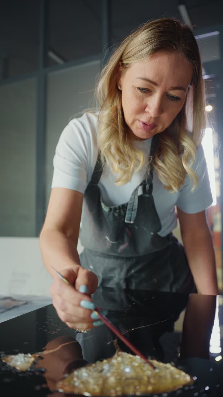 Woman Artist Painting on Glass with Gold Leaf