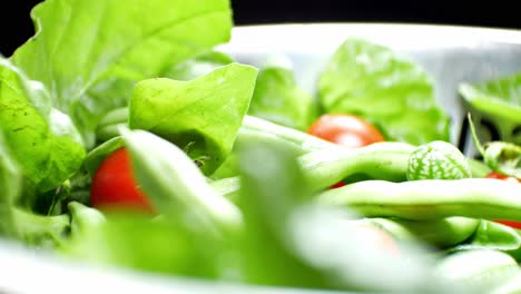 Shallow-focus-healthy-fresh-green-spinach-leaf-cucamelon-cherry-tomato-salad-bowl-closeup-slow-left-dolly-shot