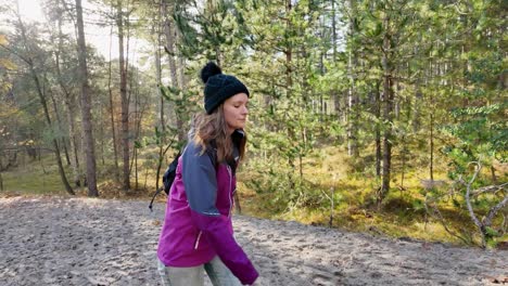 handheld tracking shot of woman walking in forest on sunny day