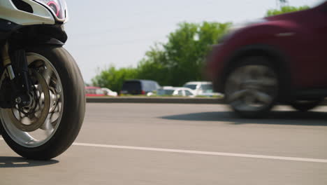 Motorcycle-drives-fast-along-empty-plain-road-on-city-street