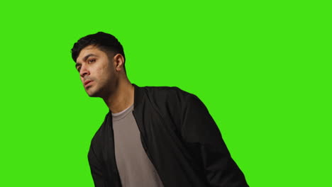 Bored-Or-Fed-Up-Young-Man-Walks-Into-Frame-Before-Standing-And-Waiting-Against-Green-Screen-Background