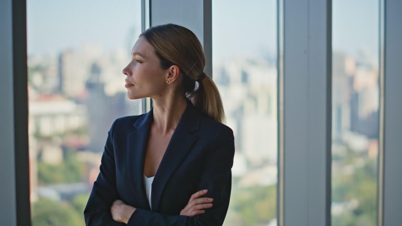 mujer ambiciosa soñando con una oficina en una ventana panorámica.