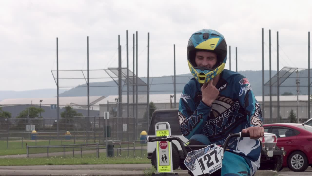 자전거를 타는 동안 백인 남자가 헬멧 끈을 풀다