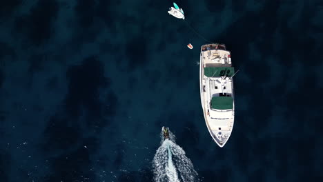 drone footage of yacht in the sea during summer jet ski