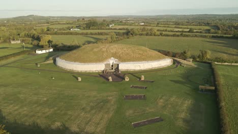 bru na boinne - newgrange monument with green meadow landscape at sunrise in county meath, ireland. - aerial shot