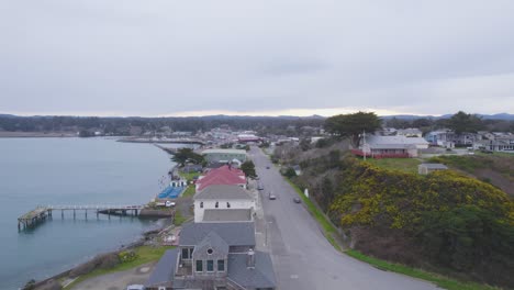 aerial dolly over beachfront properties and homes on cloudy day in bandon oregon