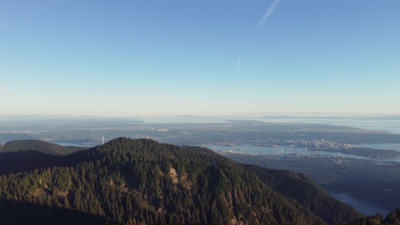 산꼭대기 나무와 고독한 풍력 터빈이 있는 크라운 산에서 밴쿠버 캐나다 bc의 놀라운 공중 전망 - 드론 샷 4k 밀기