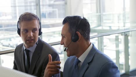 Businessmen-wearing-headsets-in-a-modern-office