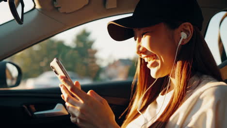 happy young woman laughing and listening to music with earphones in a car