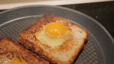 cerca de huevo frito casero sobre una tostada en sartén
