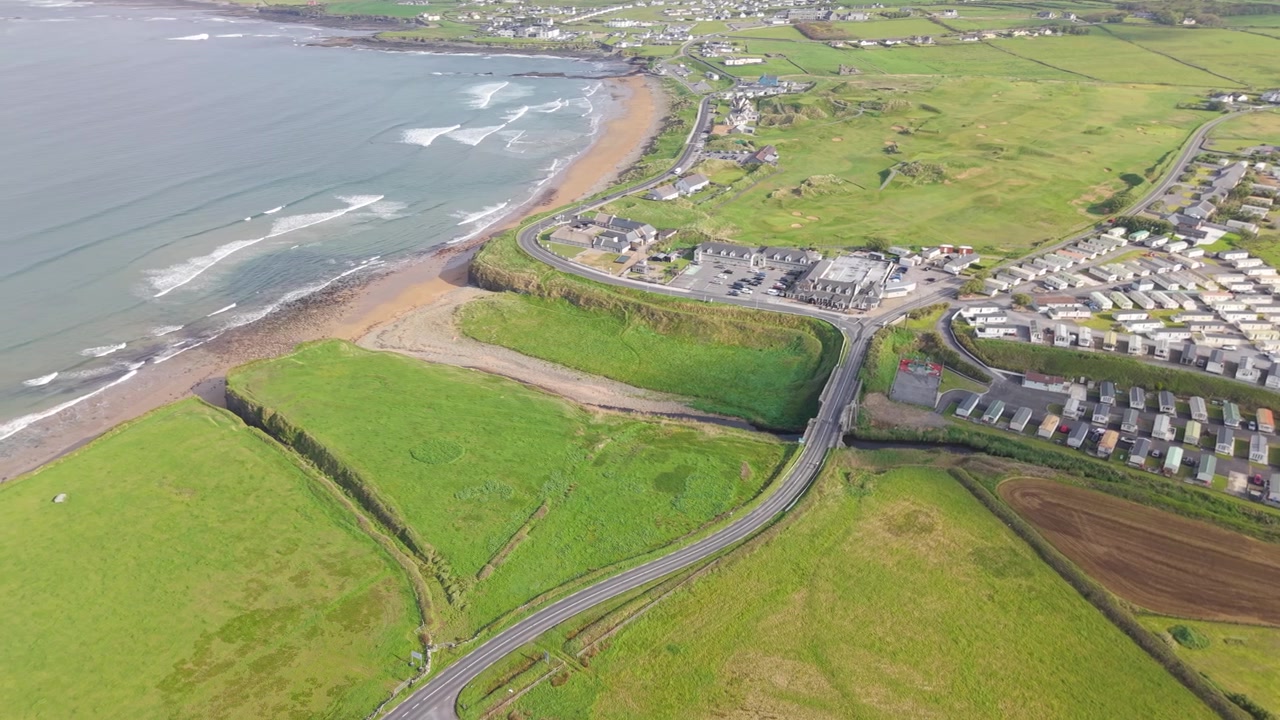 Atlantvågor rullar in över kustlandskapet vid Spanish Point Beach på Irland.