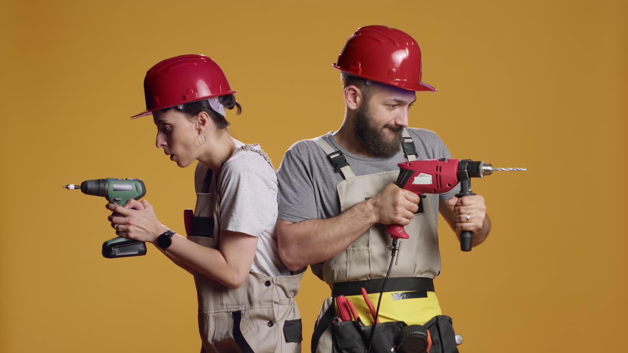 Construction workers using power drill gun to work on industrial renovation