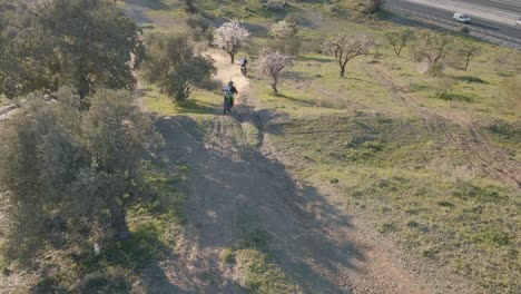 Aerial-static-shot-racing-on-a-motocross-track-in-Malaga-Spain-while-motocross-riders-jump-over-a-hill-and-perform-a-dangerous-stunt