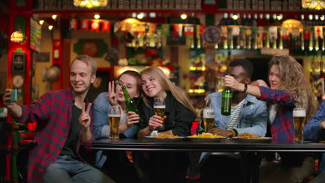 En-El-Bar-O-Restaurante,-Un-Hombre-Hispano-Se-Toma-Un-Selfie-De-Ella-Y-De-Sus-Mejores-Amigos.-Grupo-De-Jóvenes-Hermosos-En-Un-Establecimiento-Elegante.