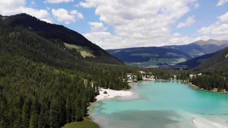 lake dobbiaco in dolomites with blue sky and some clouds