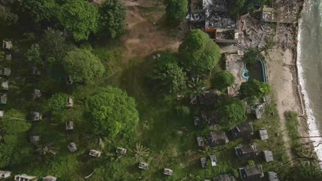 Aerial-birds-eye-view-of-a-abandoned-and-derelict-beach-bungalow-tourist-resort-in-Koh-Chang-Thailand-due-to-the-effect-of-covid-on-global-travel-and-tourism