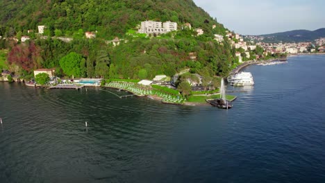 Wide-Orbit-Aerial-Springbrunnen-Am-Comer-See,-Restaurant-Am-Seeufer-Im-Freien,-Italien